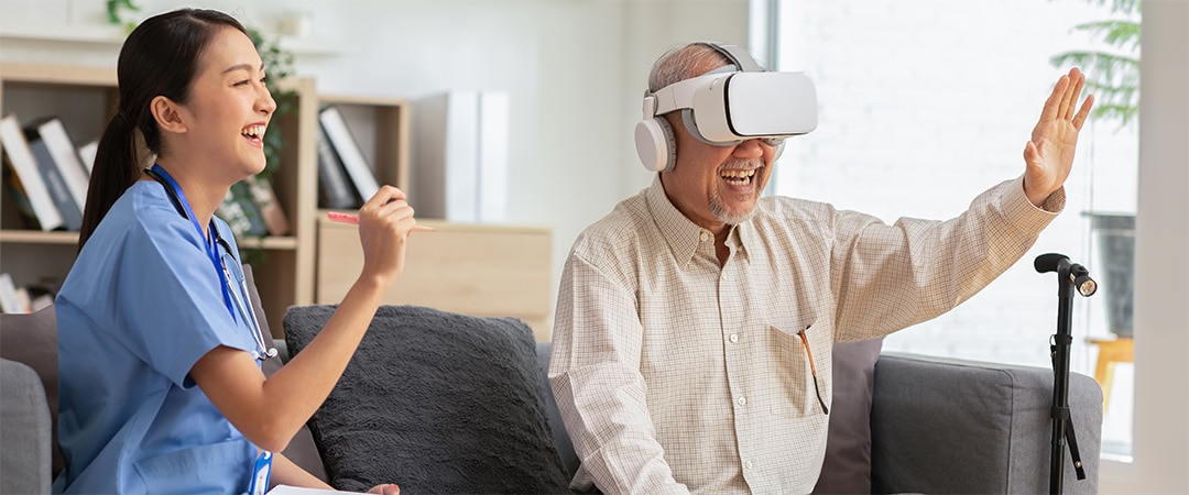 Older man playing a video game on a VR headset next to a nurse