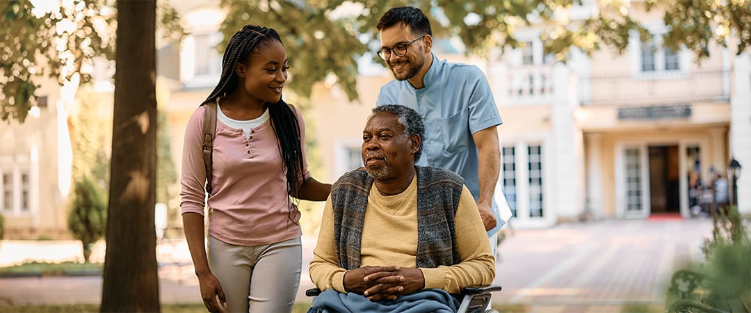 A senior man visiting with family outside